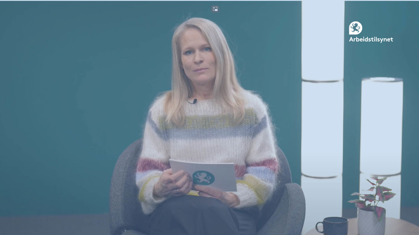 Bilde fra webinaret av programleder Karin Scheel. Hun sitter i en stol, med to lamper bak stående på gulvet, og ser inn i kamera